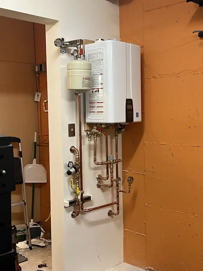 Plumbing technician inspecting water heater connections in Independence